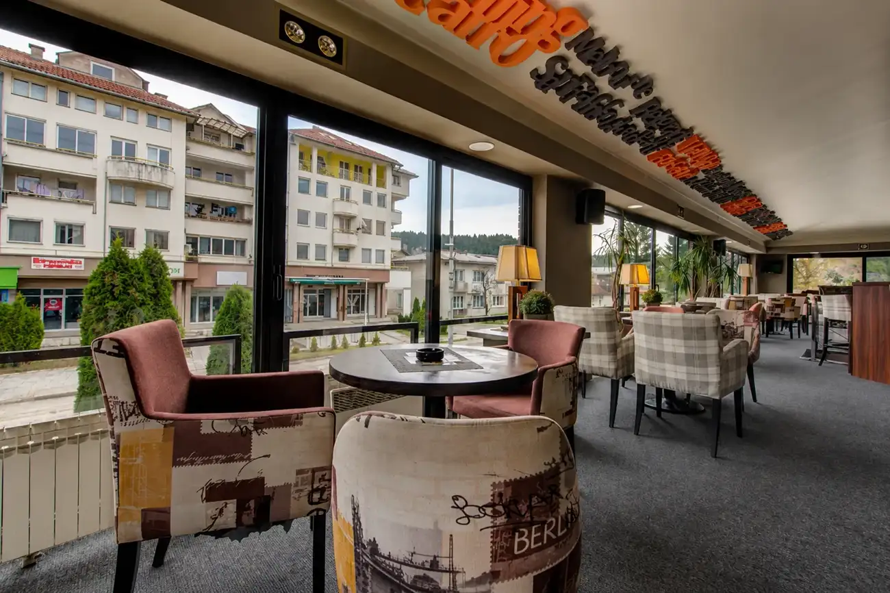 Caffe lounge of Hotel Zlatna Žita with armchairs and tall windows onto the street in Pale