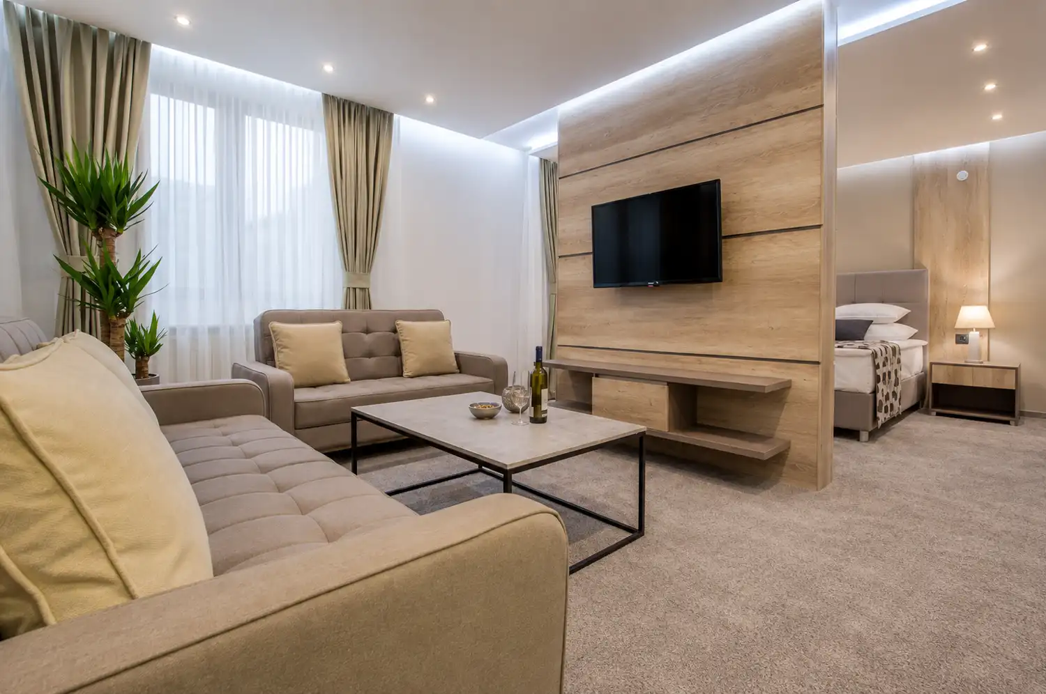 Suite with a separate living area, sofa bed and the bedroom behind a timber partition