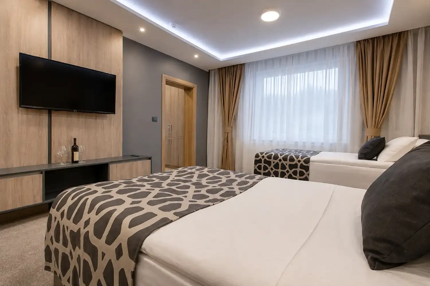 Deluxe twin room with two separate beds and a timber television wall