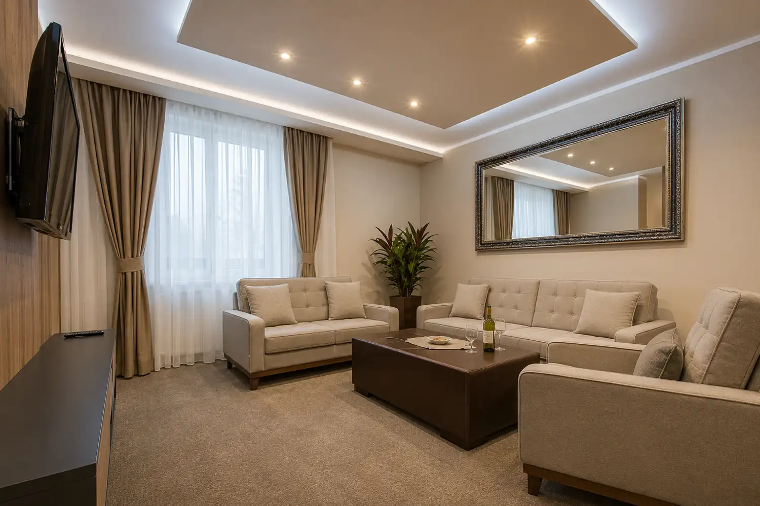 Apartment sitting room with two sofas, an armchair and a framed mirror